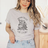 "Never Trust The Living" design on a unisex t-shirt