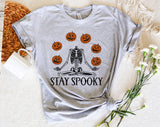 "Stay Spooky Skeleton Juggle" design on a heather gray unisex t-shirt