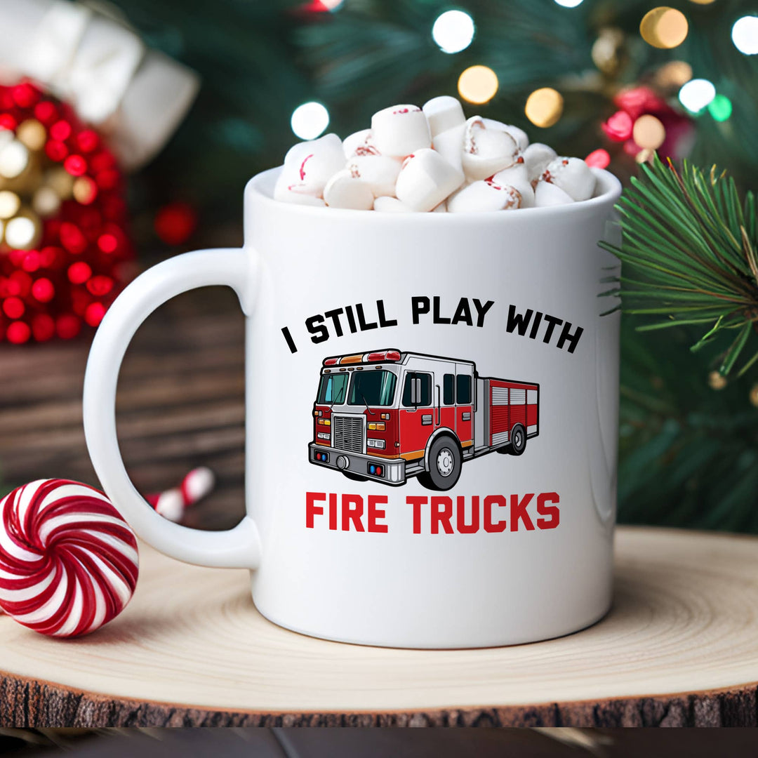 "I Still Play With Fire Trucks" design on a white ceramic coffee mug