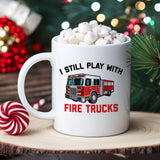 "I Still Play With Fire Trucks" design on a white ceramic coffee mug
