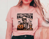 "Just Waiting For Halloween Skeleton" design on a peach unisex t-shirt