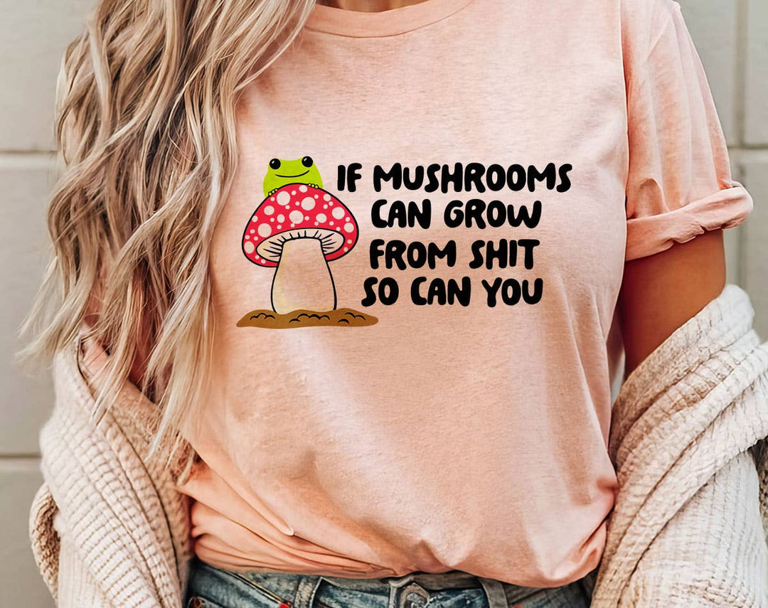 "If Mushrooms Can Grow From Sh*t" design on a peach unisex t-shirt