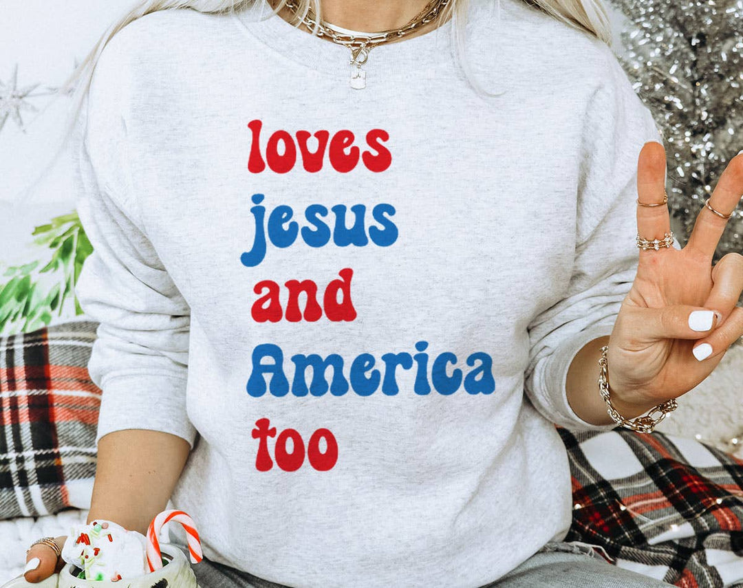 "4th of July Loves Jesus and America too" design on an ash gray unisex crewneck sweatshirt