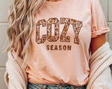 "Cozy Season Fall Leaves" design on a peach unisex t-shirt