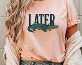 "Later Alligator" design on a peach unisex t-shirt
