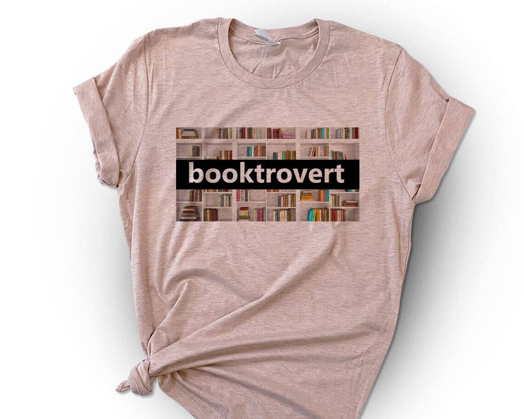 "Booktrovert Book Spines" design on a peach unisex t-shirt