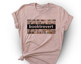 "Booktrovert Book Spines" design on a peach unisex t-shirt