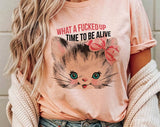 "What A F*cked Time To Be Alive Kitten" design on a peach unisex t-shirt