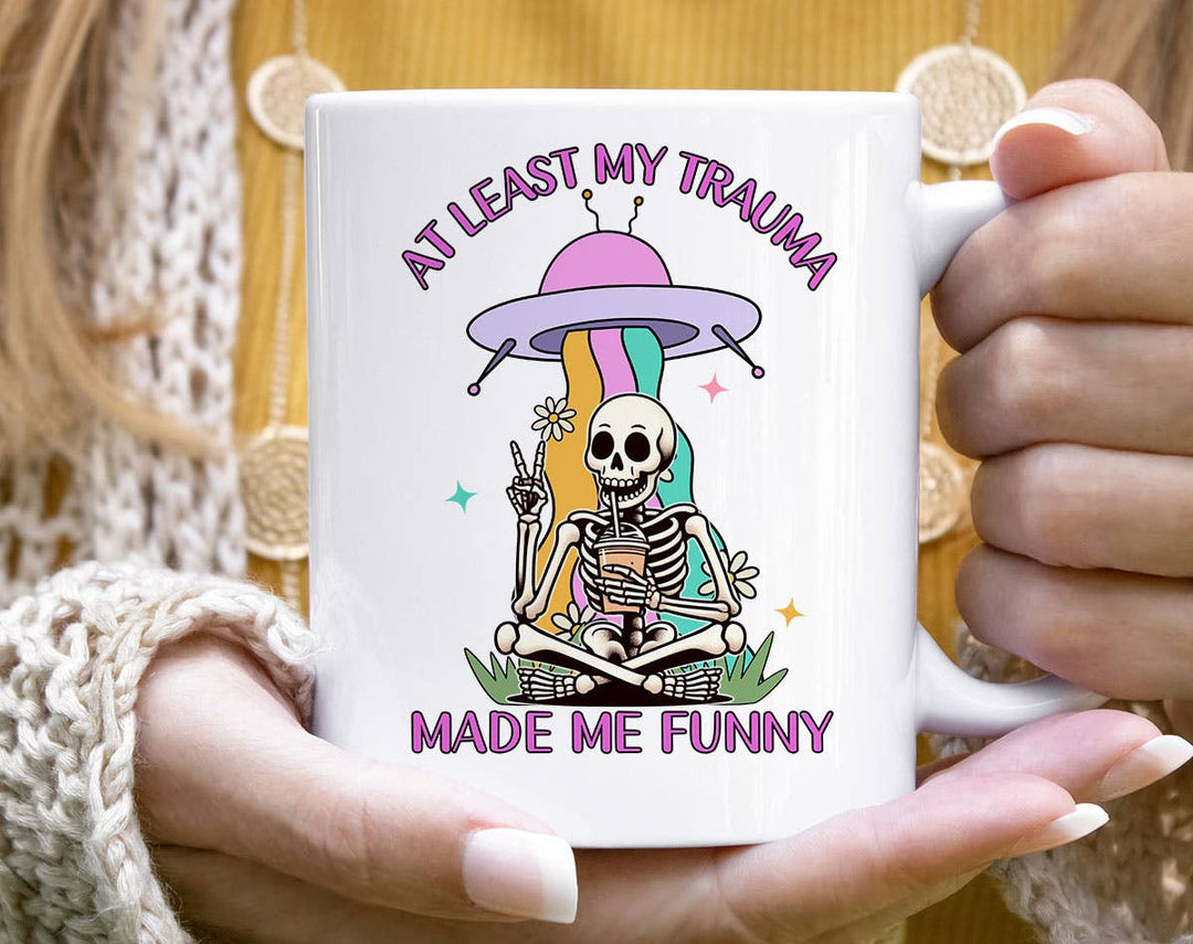 "At Least My Trauma Made Me Funny" design on a white ceramic coffee mug