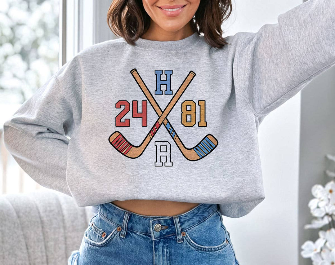 "Heated Rivalry Inspired 24 81 Hockey" design on an ash gray unisex crewneck sweatshirt
