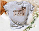 "Coffee Addict Striped Bow" design on a heather gray unisex t-shirt
