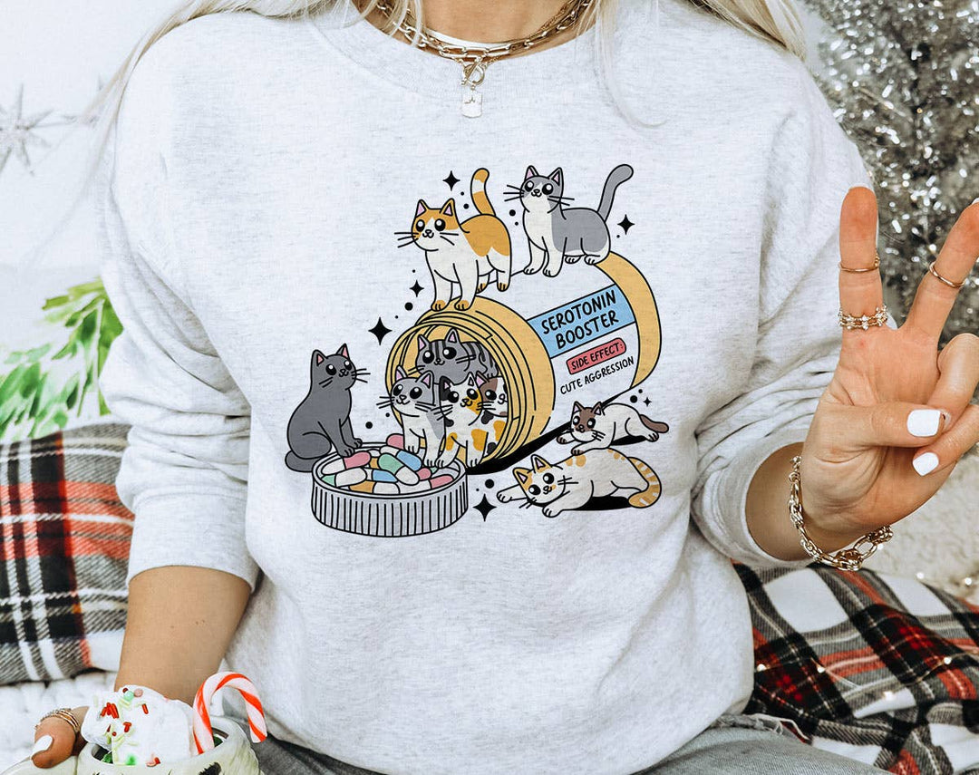 "Serotonin Booster Cats" design on an ash gray unisex crewneck sweatshirt