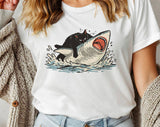 "Cat Riding Shark" design on a white unisex t-shirt