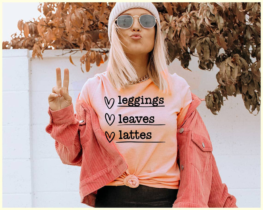 "Leggings Leaves Lattes" design on a peach unisex t-shirt