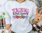 "Teaching Sweethearts 2024" design on an ash gray unisex crewneck sweatshirt