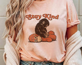 "Stay Kind Baby Punch Monkey" design on a peach unisex t-shirt