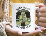 "Beam Me Up, This Place Sucks Funny Alien" design on a white ceramic coffee mug