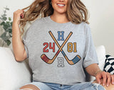"Heated Rivalry 24 81 Hockey" design on a heather gray unisex t-shirt