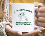 "My Tummy Hurts Frog" design on a white ceramic coffee mug