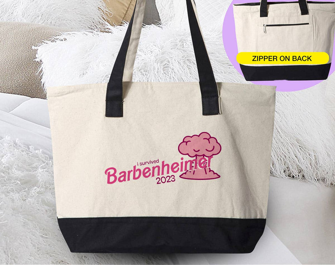 "I Survived BarbenHeimer" design on a natural canvas zippered tote bag