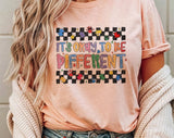 "It's Okay To Be Different Autism Awareness" design on a peach unisex t-shirt